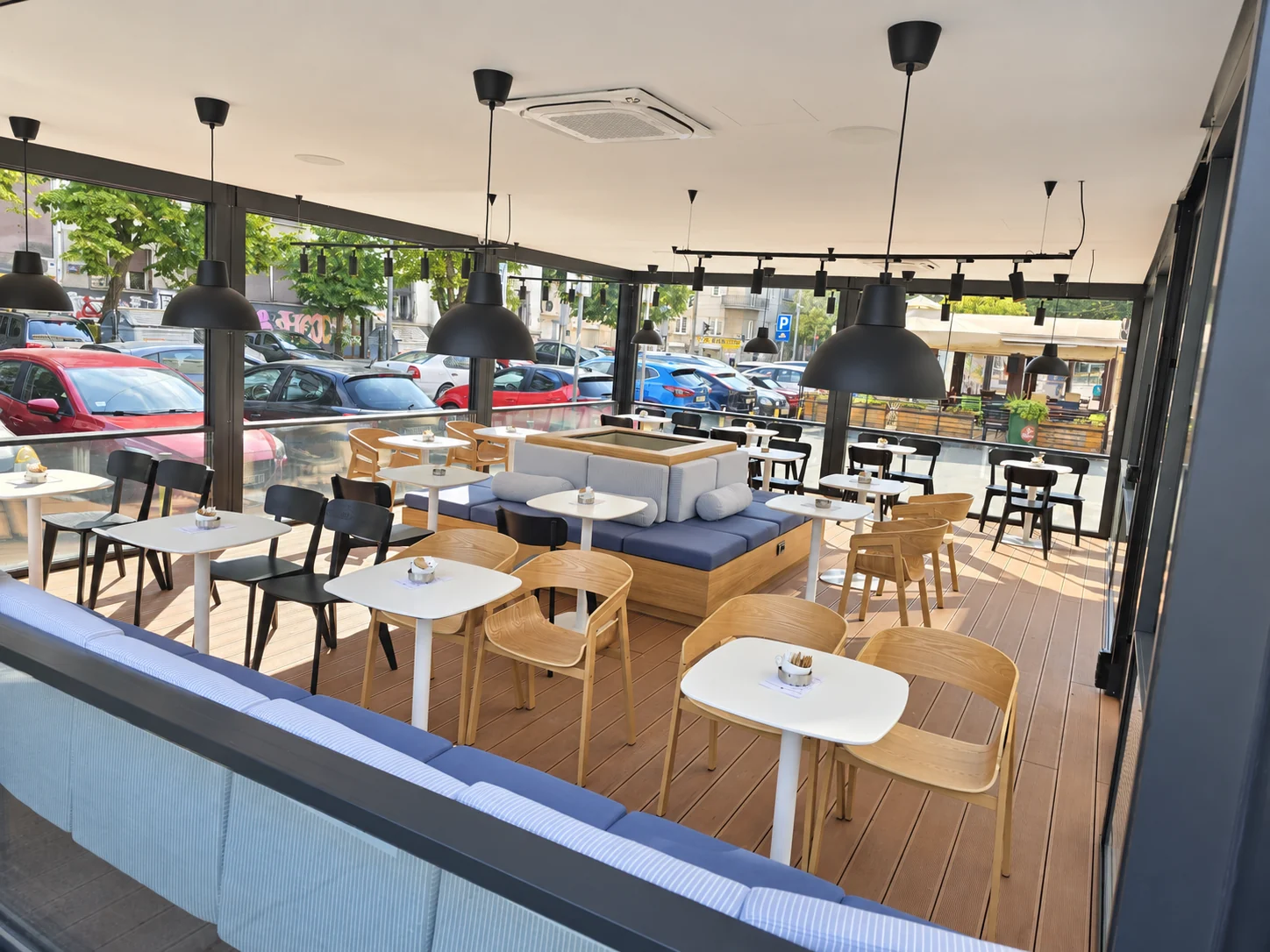 Uređen enterijer kafea sa drvenim podom i plavim klupama